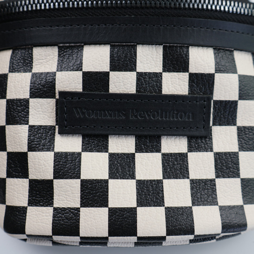 Close up on front of bum bag with black and white checkered leather. 