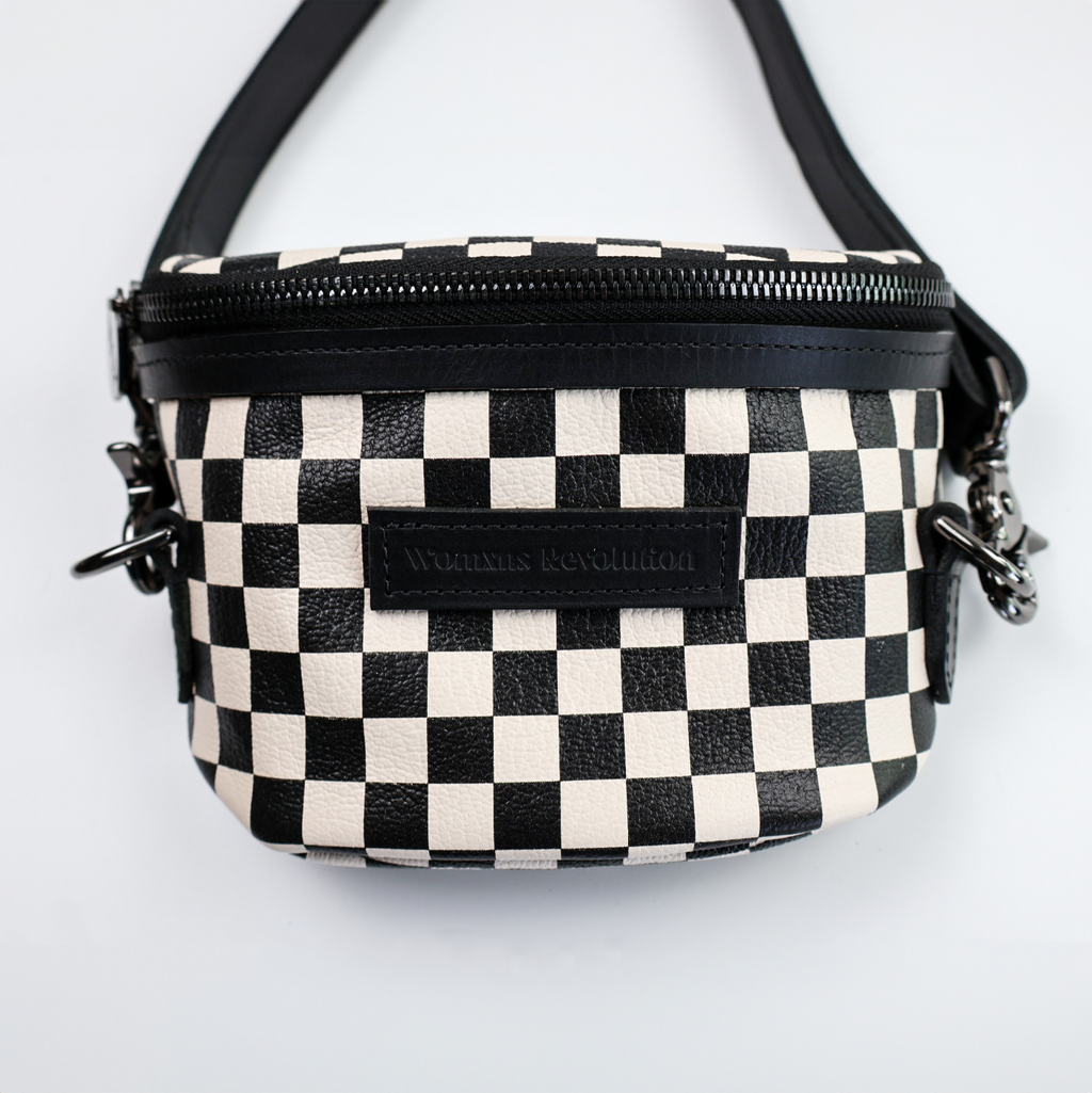 A small, black and white checkered leather bum bag with a zipper closure, gunmetal-tone hardware, and a detachable strap.