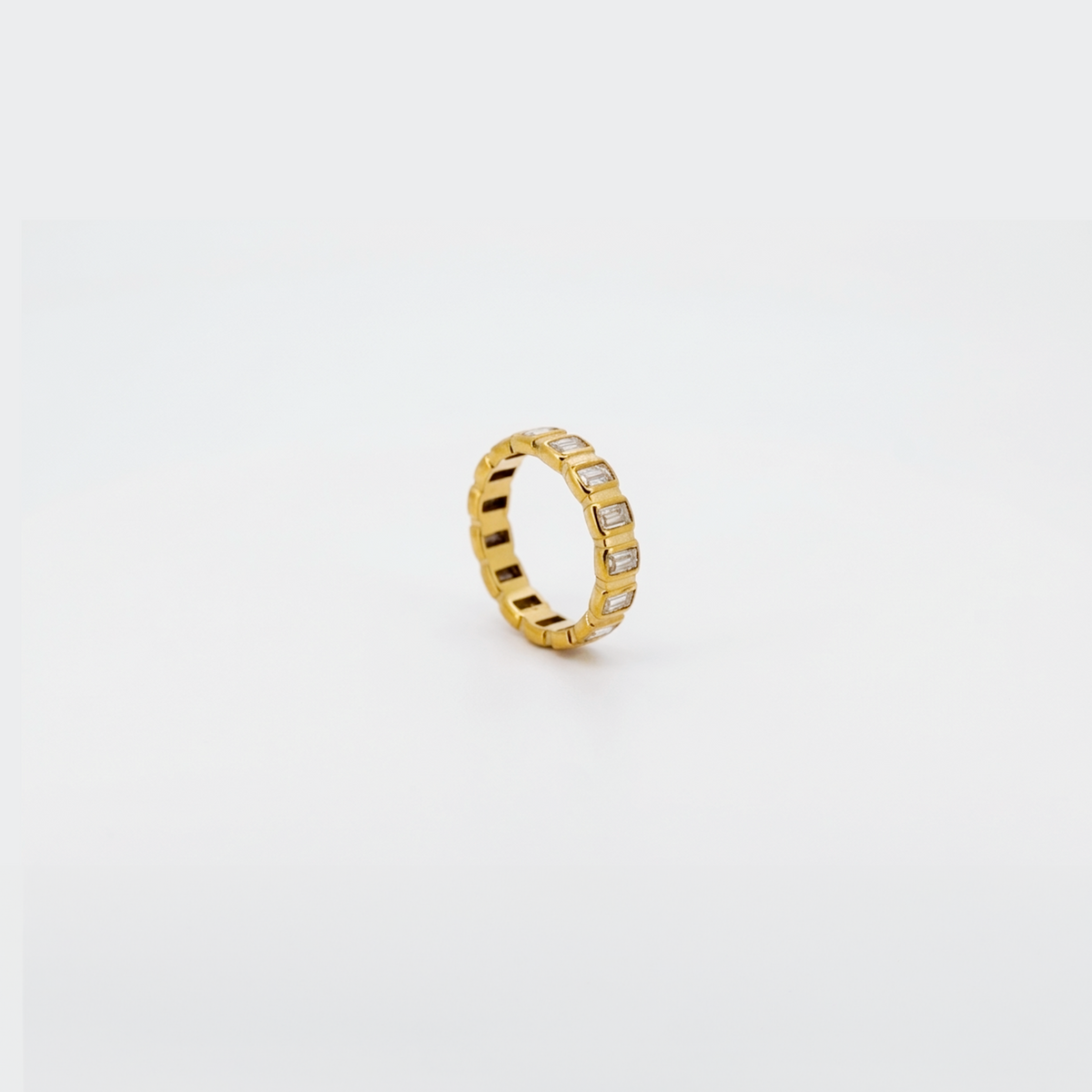 Gold eternity band ring set with baguette cubic zirconia