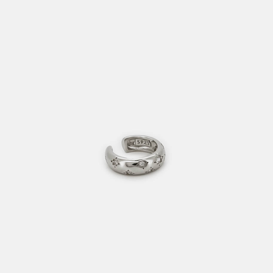 Silver ear cuff with star-shaped crystal details, shown on a white background.
