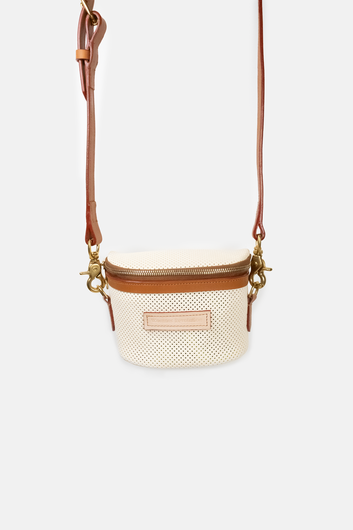 Perforated ivory crossbody bag with brown leather strap on a white background