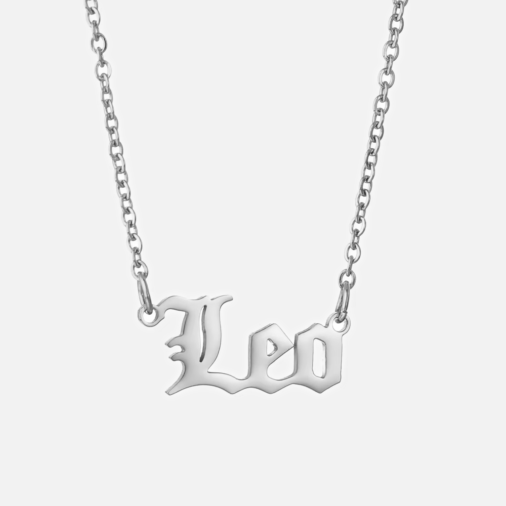 A silver stainless steel necklace with the word 'Leo' written in a bold, gothic font on a chain with an extender.