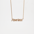 A gold-plated brass chain pendant necklace with the word 'FEARLESS' in bold script, featuring sparkling crystals.