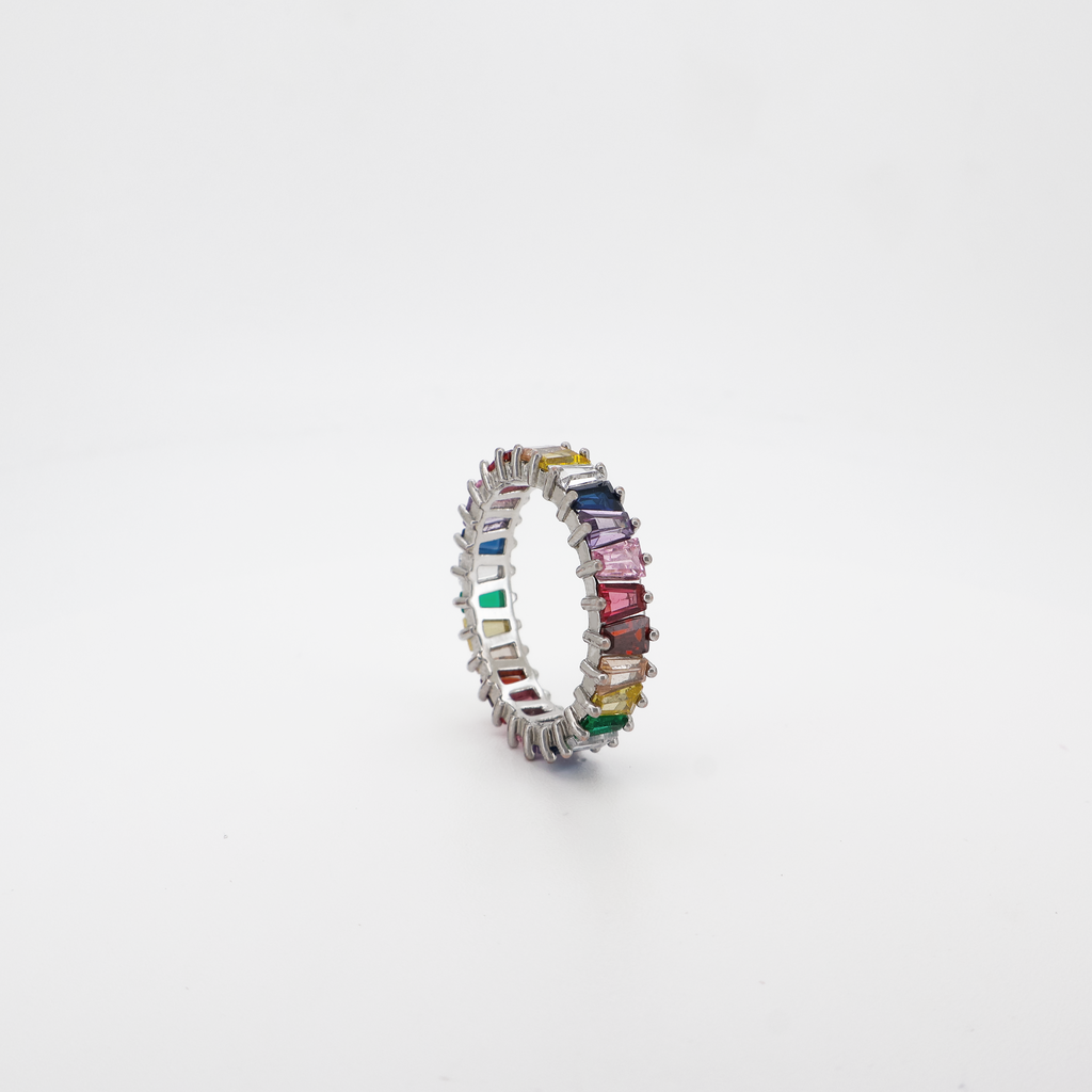 A multicolored baguette cut eternity ring with a high-polished finish on a white background.