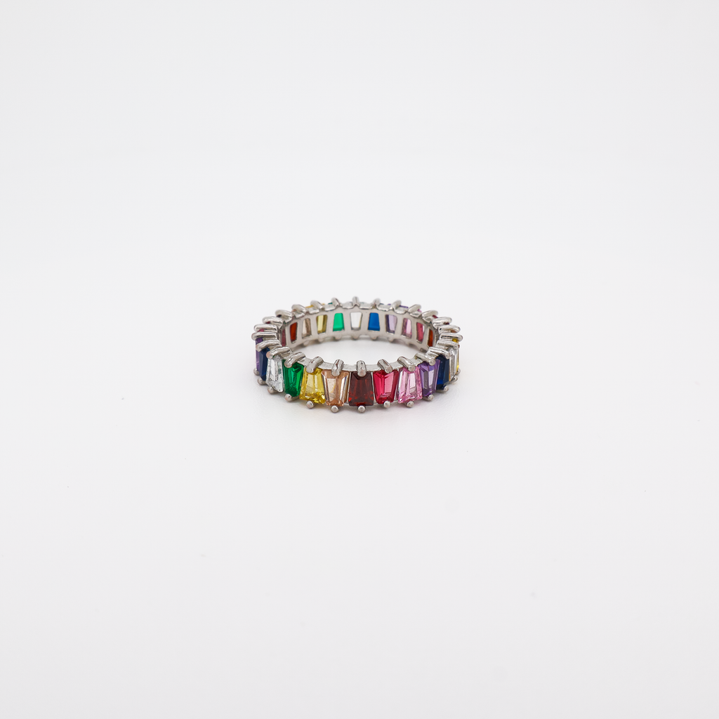 a silver eternity band ring set with multicolor baguette-cut crystals on a white background