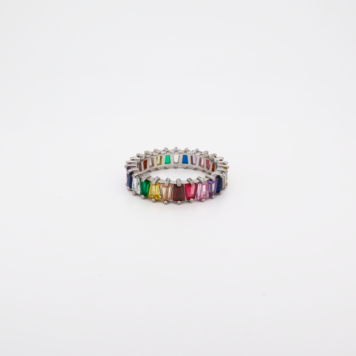a silver eternity band ring set with multicolor baguette-cut crystals on a white background