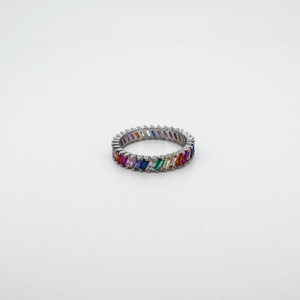 Silver band ring set with multicolor baguette-cut crystals, photographed on a white background.